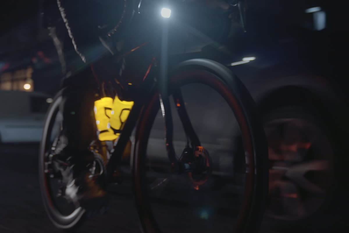 The Orb MKII bike light and water bottle glowing orange on a night ride